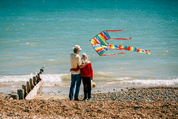istock Senior couple flying colorful rainbow kite at beach 1321308062