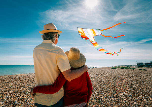 istock Senior couple flying colorful rainbow kite at beach 1321308067