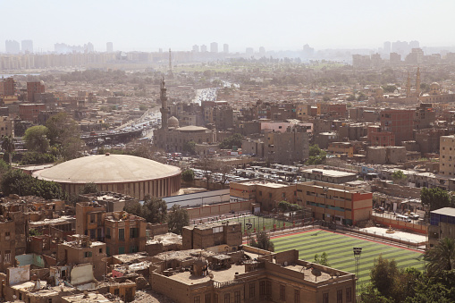 View of crowded cityscape with mosque and stadium, Cairo, Egypt.