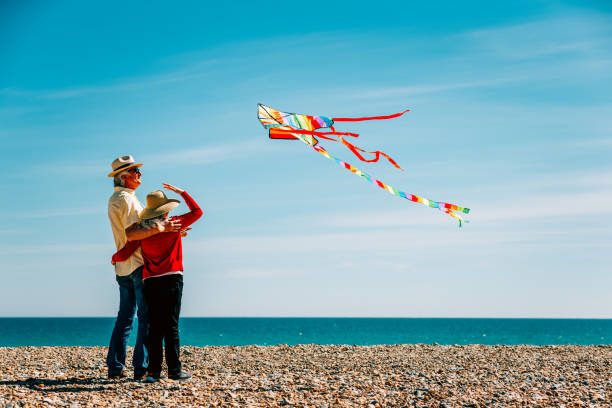 istock Senior couple flying colorful rainbow kite at beach 1321308263