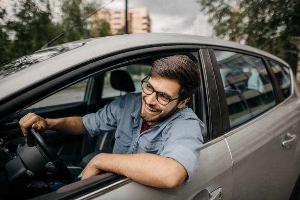I found the parking spot Young man driving car in reverse gear, trying to park the car car insurance stock pictures, royalty-free photos & images