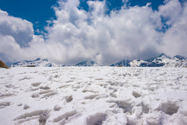 istock snow cap mountains with footmarks and bright blue sky 1321311253