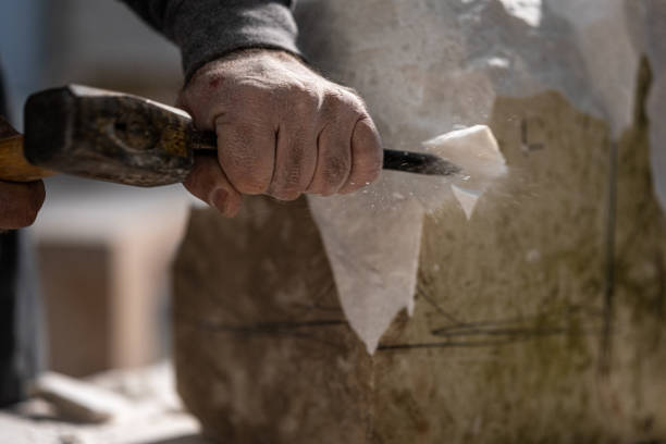 istock Stonemason chiselling a block of stone in workshop 1321311546