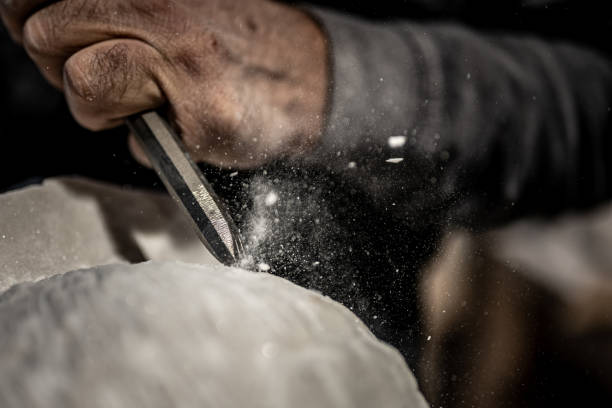 istock Stonemason chiselling surface of white stone 1321311597