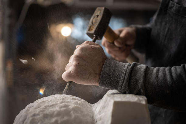 istock Stonemason chiselling surface of white stone 1321311604