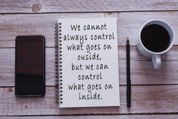 Motivational quote on notepad. We cannot always control what goes on outside, but we can control what goes on inside. stock photo