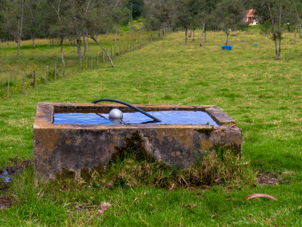 A rustic rural concrete water tank in the field of a farm near the town of Arcabuco, in the central Andean mountains of Colombia.