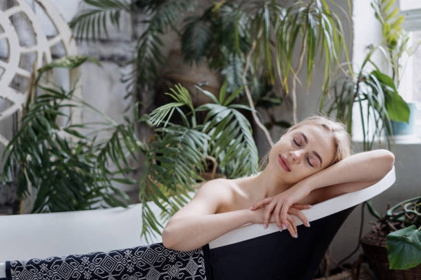 istock Dreamy and young woman taking bath in bathroom 1321315388