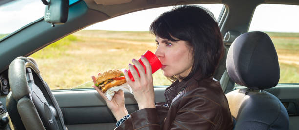 istock Businesswoman eats a burger on the way to work 1321319390
