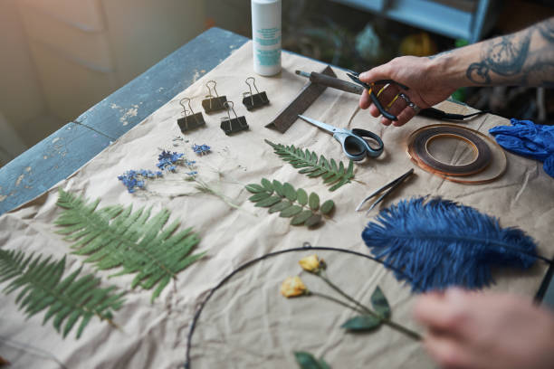 istock Young man holding pliers and making herbarium in workshop 1321319472