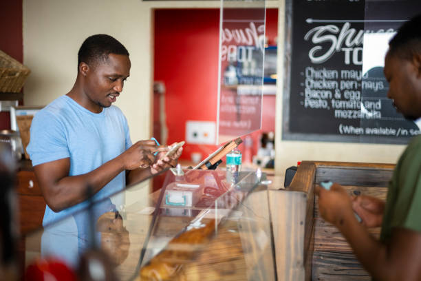 istock African cafe barista using contactless payment system with customer 1321320183