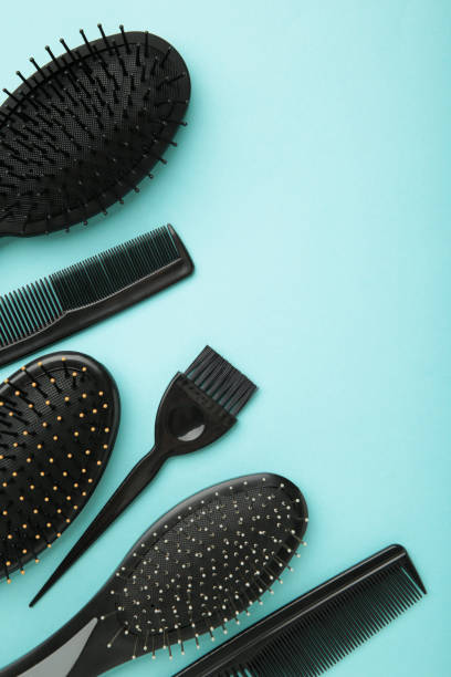 istock Hair tools, beauty and hairdressing concept - different brushes or combs on blue background. Vertical photo with copy space 1321320821