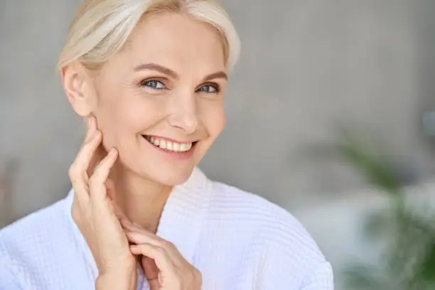 Photo of Portrait of smiling mid age woman looking at camera. Skin care concept.