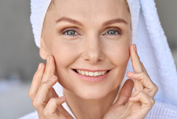 istock Happy smiling mid age woman looking at camera touching face with fingers. 1321321761