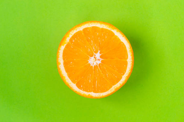 istock Top view of one orange round fruit on bright green background. Rich citrus texture. Copy space 1321322228