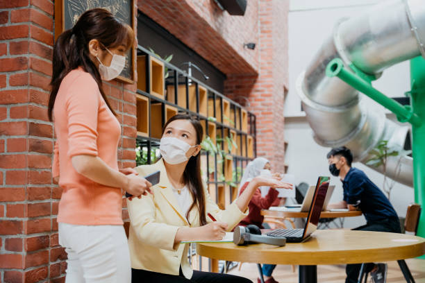 istock Asian business professionals with protective face mask working in co-working space 1321323642