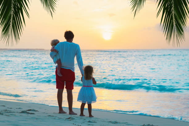 istock father and kids walking on beach at sunset 1321326935