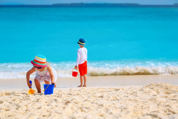 istock boy and girl play with sand on beach vacation 1321327078
