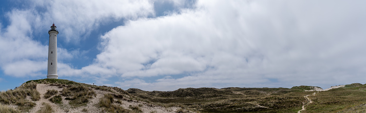A panorama view of sand dunes on the Jutland coast of Denmark with the Lyngvid Fyr lighthouse