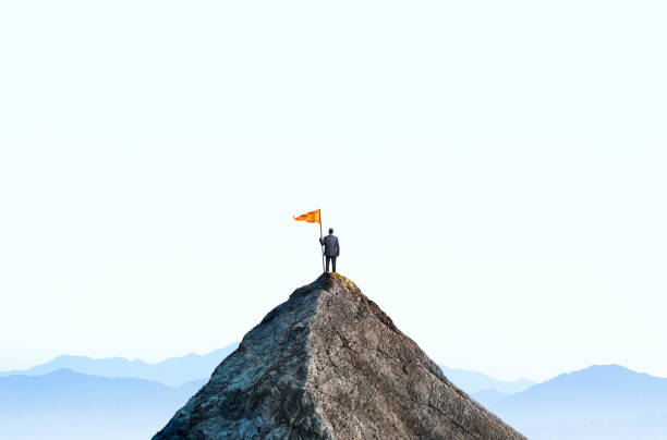 l’homme d’affaires au sommet de mountain peak tient un grand drapeau - dessus photos et images de collection