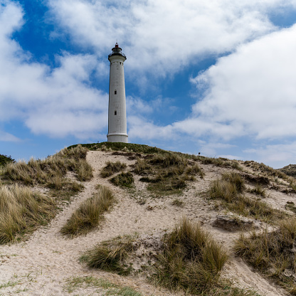 A view of sand dunes on the Jutland coast of Denmark with the Lyngvid Fyr lighthouse