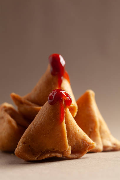 gros plan de samosa épicé et sucré fraîchement cuit rempli de fruits secs épicés chutney sec traditionnellement authentique rajasthani avec ketchup de tomate. - sauces sweet sauce cooking traditional culture photos et images de collection