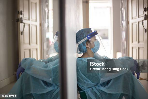 Asian Chinese Female Front Liner Tired Sitting On Floor During Pandemic Stock Photo - Download Image Now