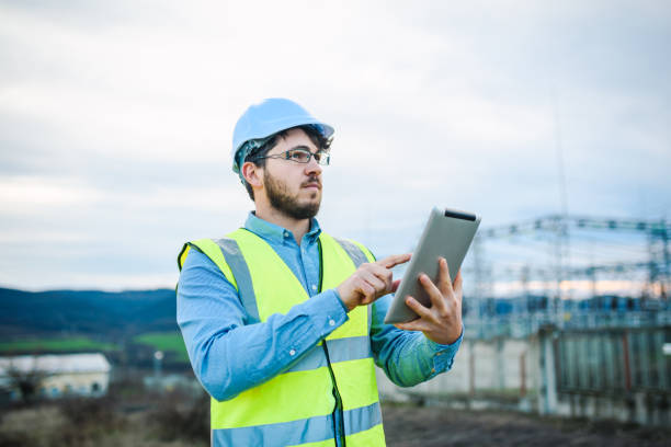 istock Electrical engineer working on a tablet in front of Electricity power station 1321331328