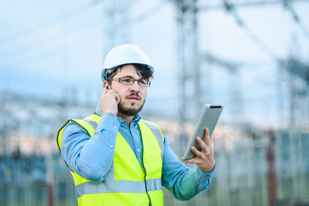 istock Electrical engineer working on a tablet in front of Electricity power station 1321331333