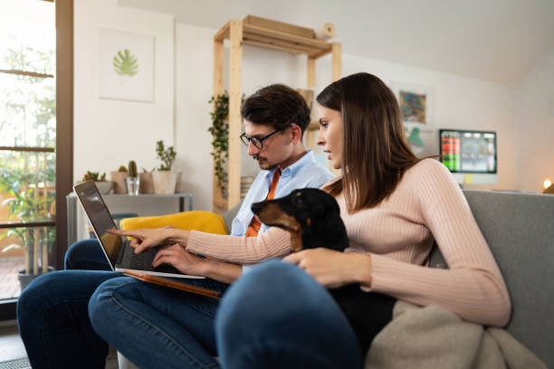 istock Young couple using wireless technology for tracking and trading stocks at home 1321334182