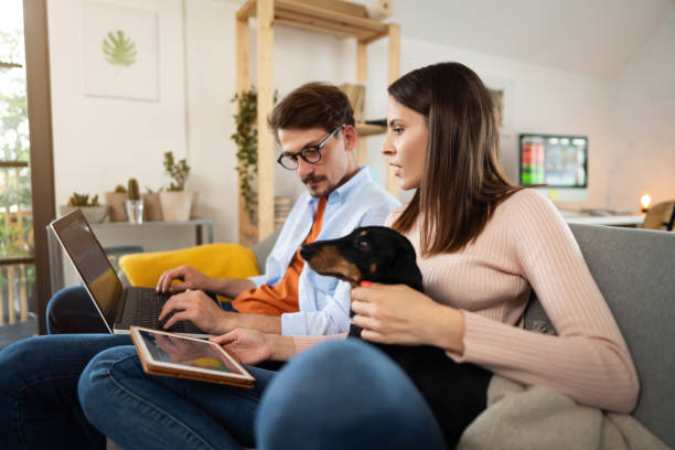 Young couple using technology for tracking and trading stocks