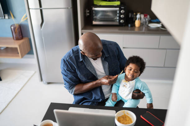 istock Father feeding baby son and working at home 1321335281