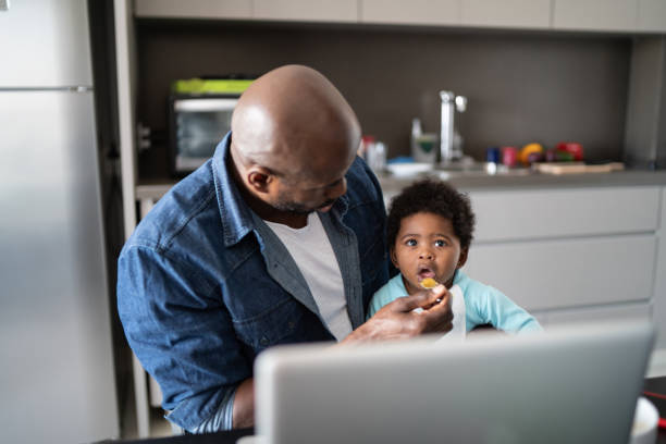 istock Father feeding baby son and working at home 1321335282