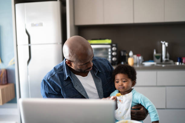 istock Father feeding baby son and working at home 1321335310