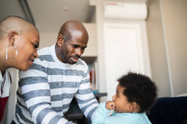 istock Mother helping father changing baby's clothes at home 1321335383
