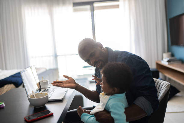 istock Father with crying baby boy while working at home 1321335416