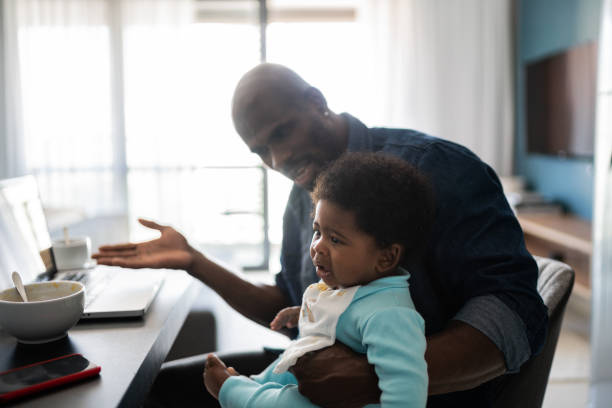 istock Father with crying baby boy while working at home 1321335481
