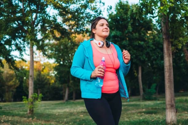 istock Young overweight woman running 1321339426