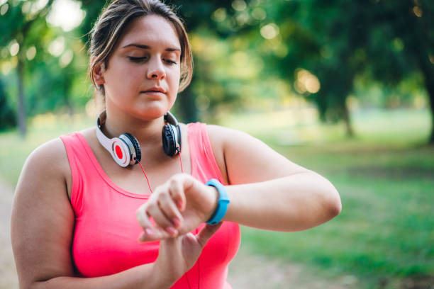 istock Female overweight runner checking smart watch 1321339663