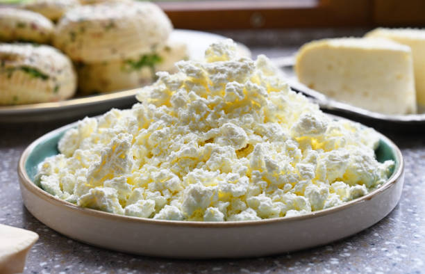 Cottage cheese, farmer's cheese on the kitchen table Cottage cheese, farmer's cheese on the kitchen table. Fresh home made cheese curd cheese stock pictures, royalty-free photos & images