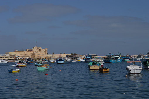 a view of fishing boats parked in Alexandria harbor near Citadel of Qaitbay.
