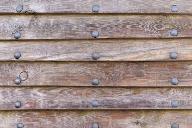 Photo of Wood paneling of an old ship with metal rivets, texture, background