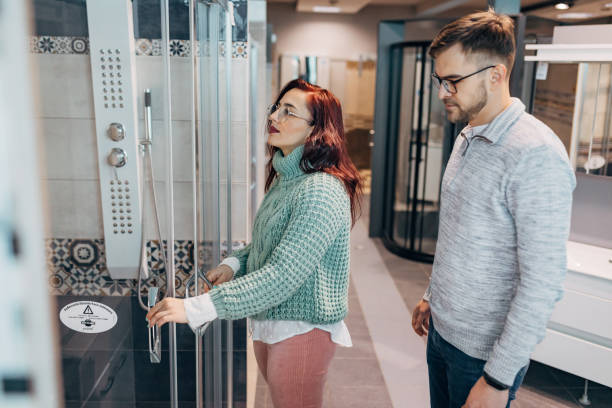 istock Modern and curious young couple observing the interesting shower, at store showroom, while shopping bathroom essentials for their new home 1321349890