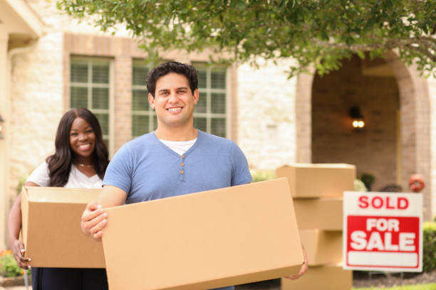 istock Excited young couple moves boxes into their new home. 1321354664