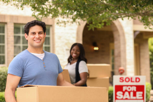 istock Excited young couple moves boxes into their new home. 1321355007
