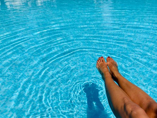 istock Female legs in swimming pool. Copy space 1321357106