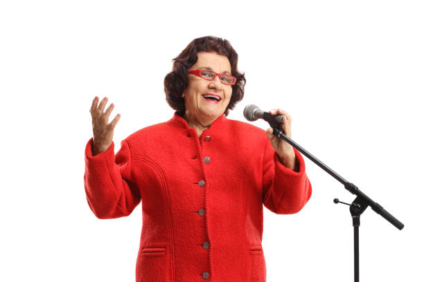 istock Elderly lady in a red coat singing on a microphone 1321359603