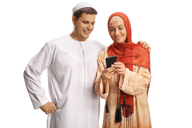 Young muslim man and woman using a smartphone Young muslim man and woman using a smartphone isolated on white background mullah photos stock pictures, royalty-free photos & images