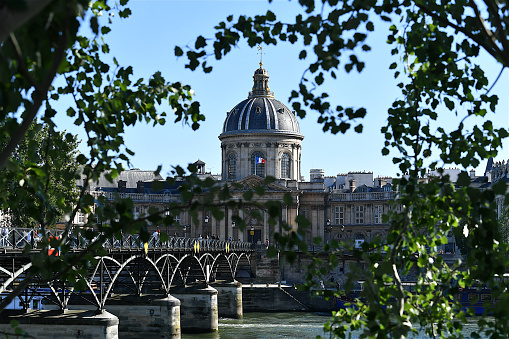 Paris, France-05 31 2021:People on the Pont des arts crossing the Seine river leading to the building of the Institut de France in Paris, which is a French learned society, grouping five académies, including the Académie Française.