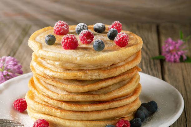 istock Stack of pancakes with fresh berries on a white plate on the table 1321362372